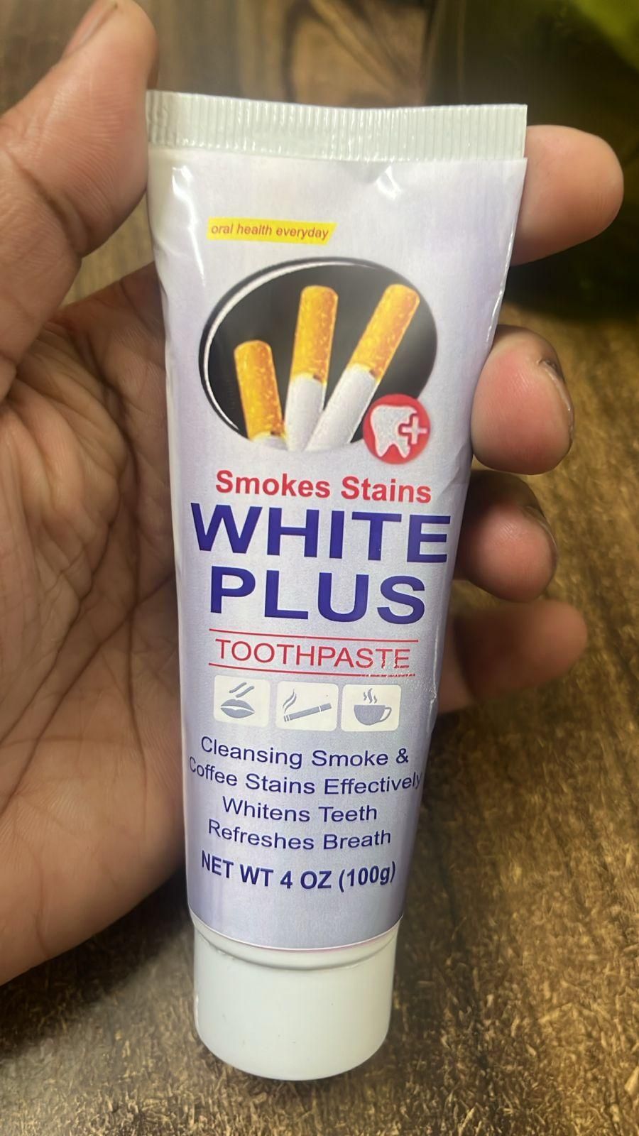 Smoke Stains White Plus Toothpaste 200g Pack of 2 shown in hand for effective stain removal and refreshing breath.